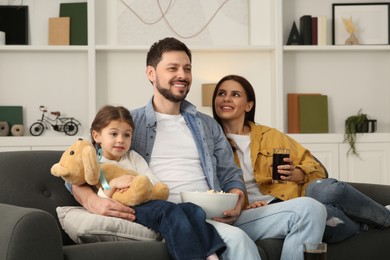 Photo of Happy family watching TV on sofa at home