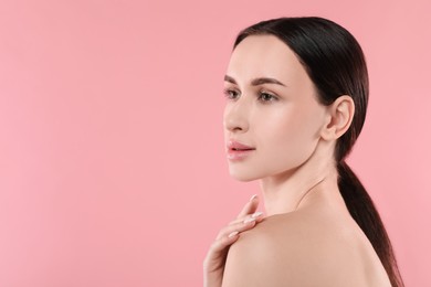 Portrait of beautiful young woman on pink background. Space for text