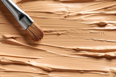 Skin foundation and makeup brush as background, closeup