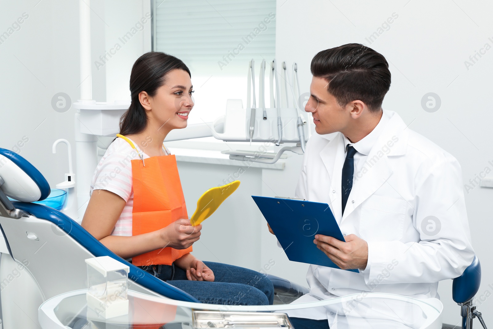 Photo of Professional dentist working with patient in clinic