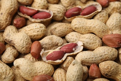 Many fresh unpeeled peanuts as background, closeup