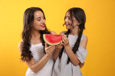 Photo of Happy girls with watermelon on yellow background