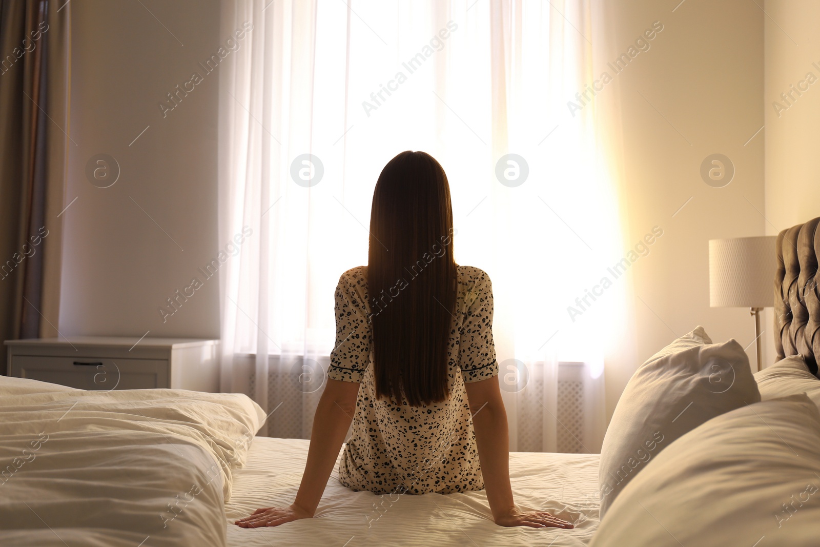 Photo of Young woman on bed at home. Lazy morning