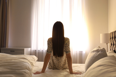 Photo of Young woman on bed at home. Lazy morning