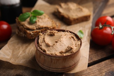 Photo of Bowl with delicious meat pate on wooden table, closeup