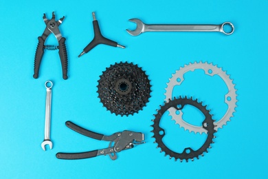 Set of different bicycle tools and parts on color background, flat lay
