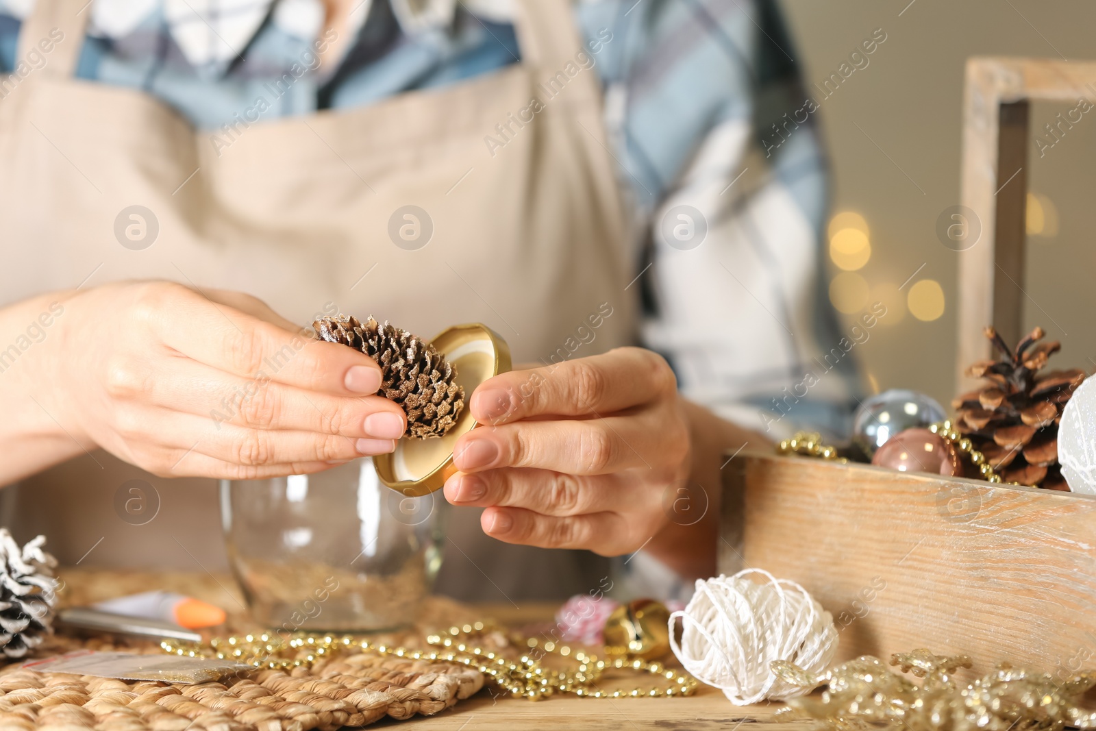 Photo of Woman making snow globe at wooden table, closeup