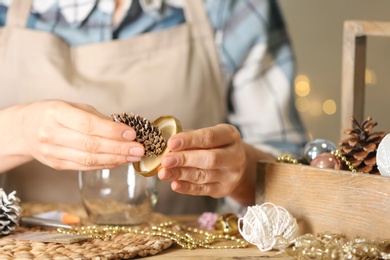 Photo of Woman making snow globe at wooden table, closeup