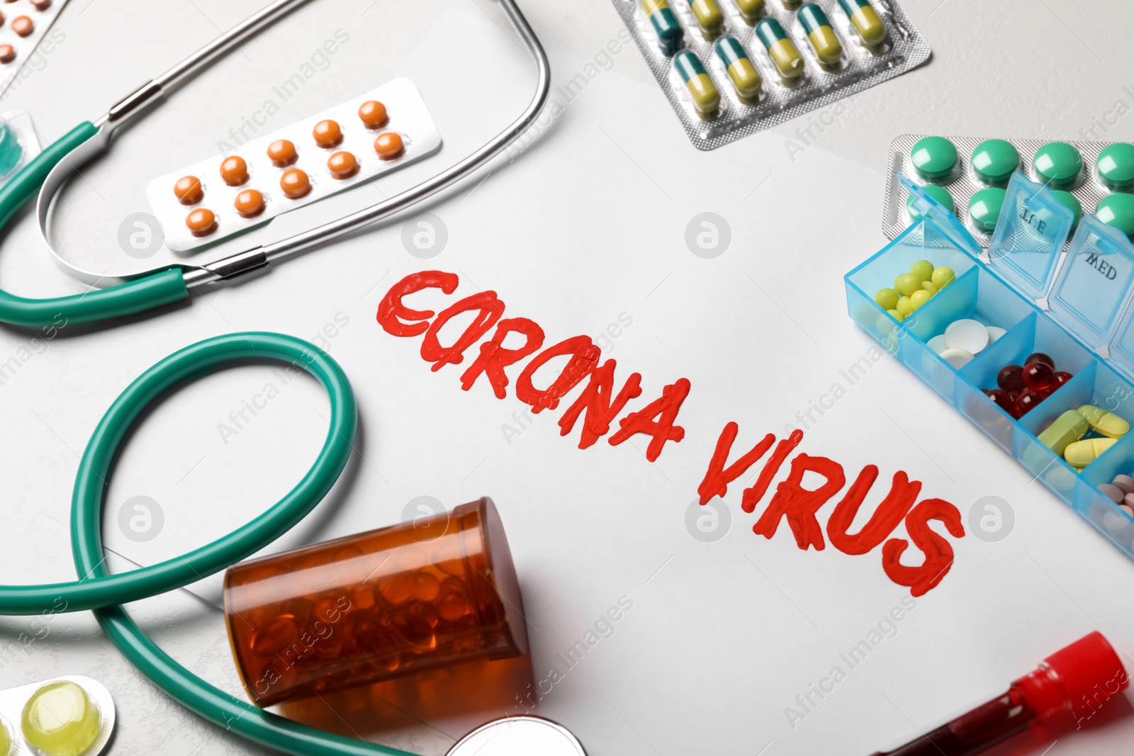 Photo of Phrase CORONA VIRUS and medicines on white background