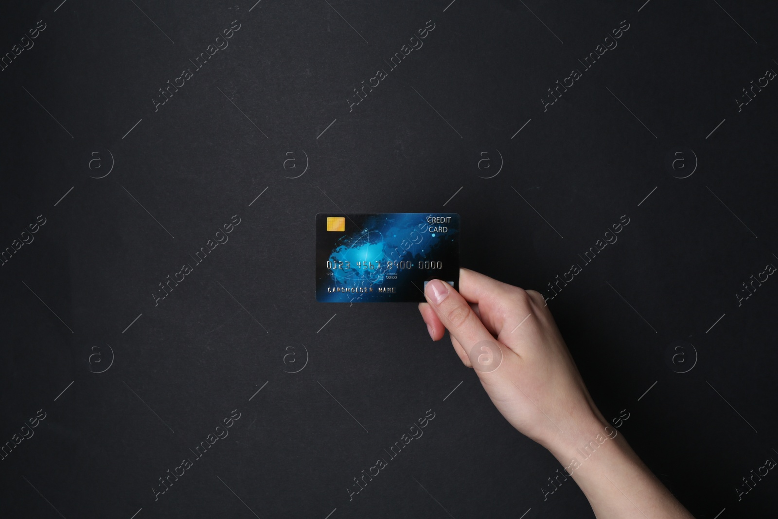 Photo of Woman holding credit card on black background, closeup