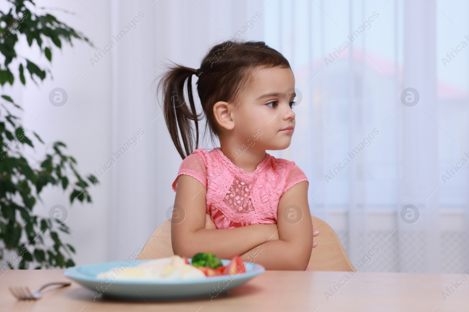 Photo of Cute little girl refusing to eat her breakfast at home