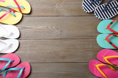 Photo of Many different flip flops on wooden background, flat lay. Space for text