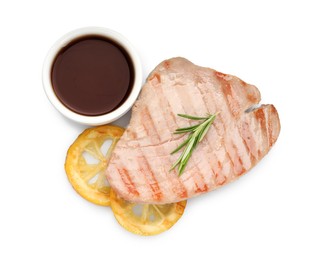 Photo of Delicious tuna steak with sauce, lemon and rosemary isolated on white, top view