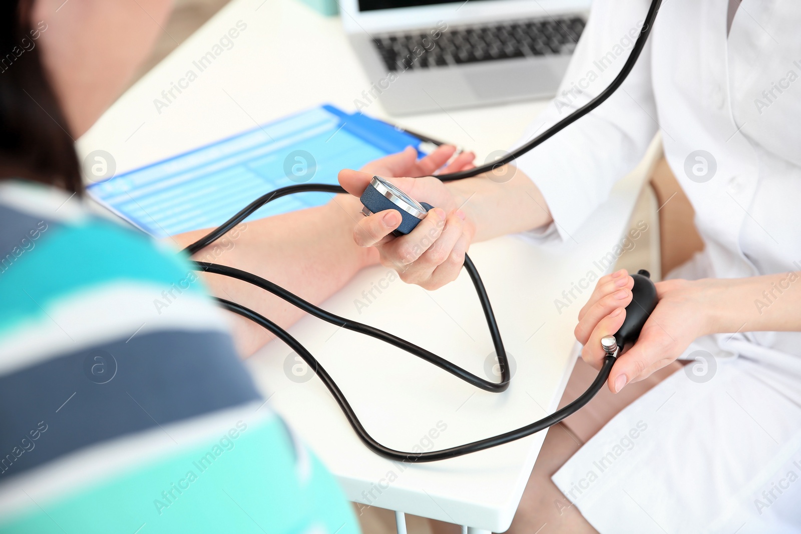 Photo of Female doctor measuring blood pressure of overweight woman in clinic