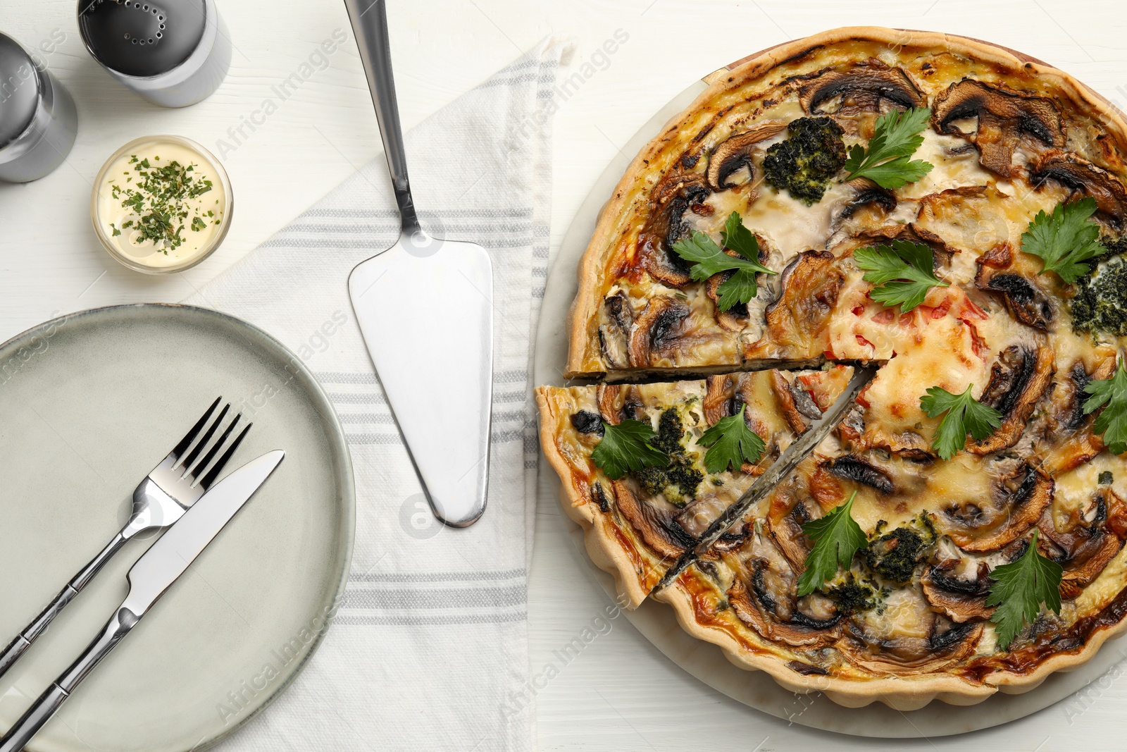 Photo of Delicious quiche with mushrooms and parsley served on white wooden table, flat lay
