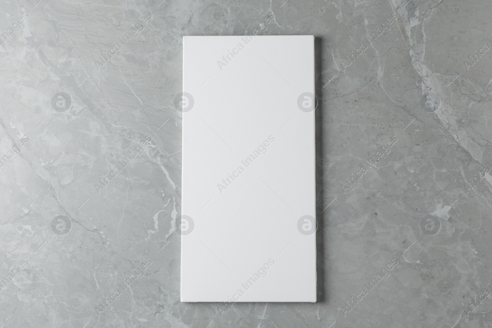 Photo of Blank canvas on grey marble table, top view. Space for text