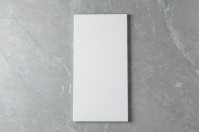 Photo of Blank canvas on grey marble table, top view. Space for text