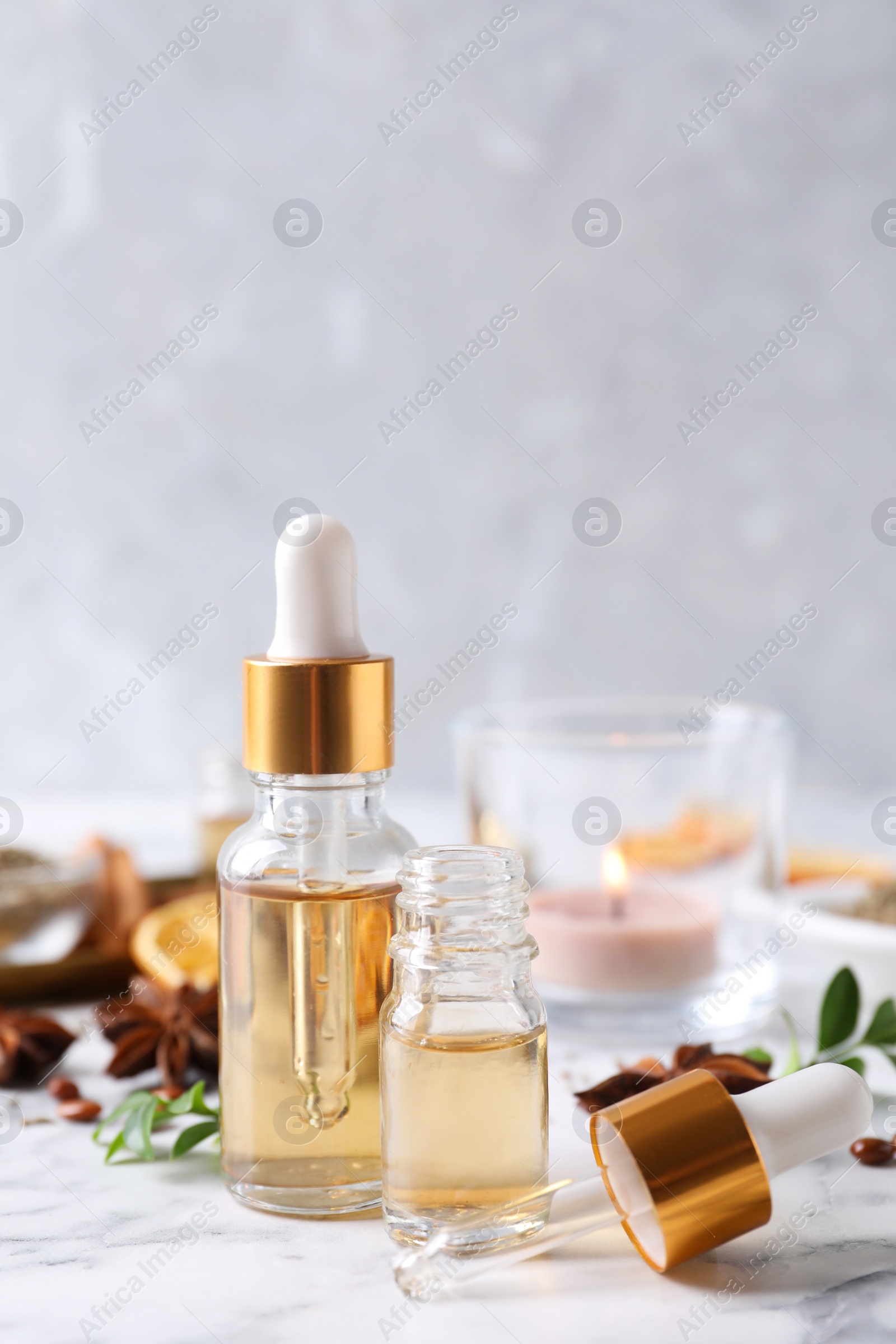 Photo of Anise essential oil and spice on white table