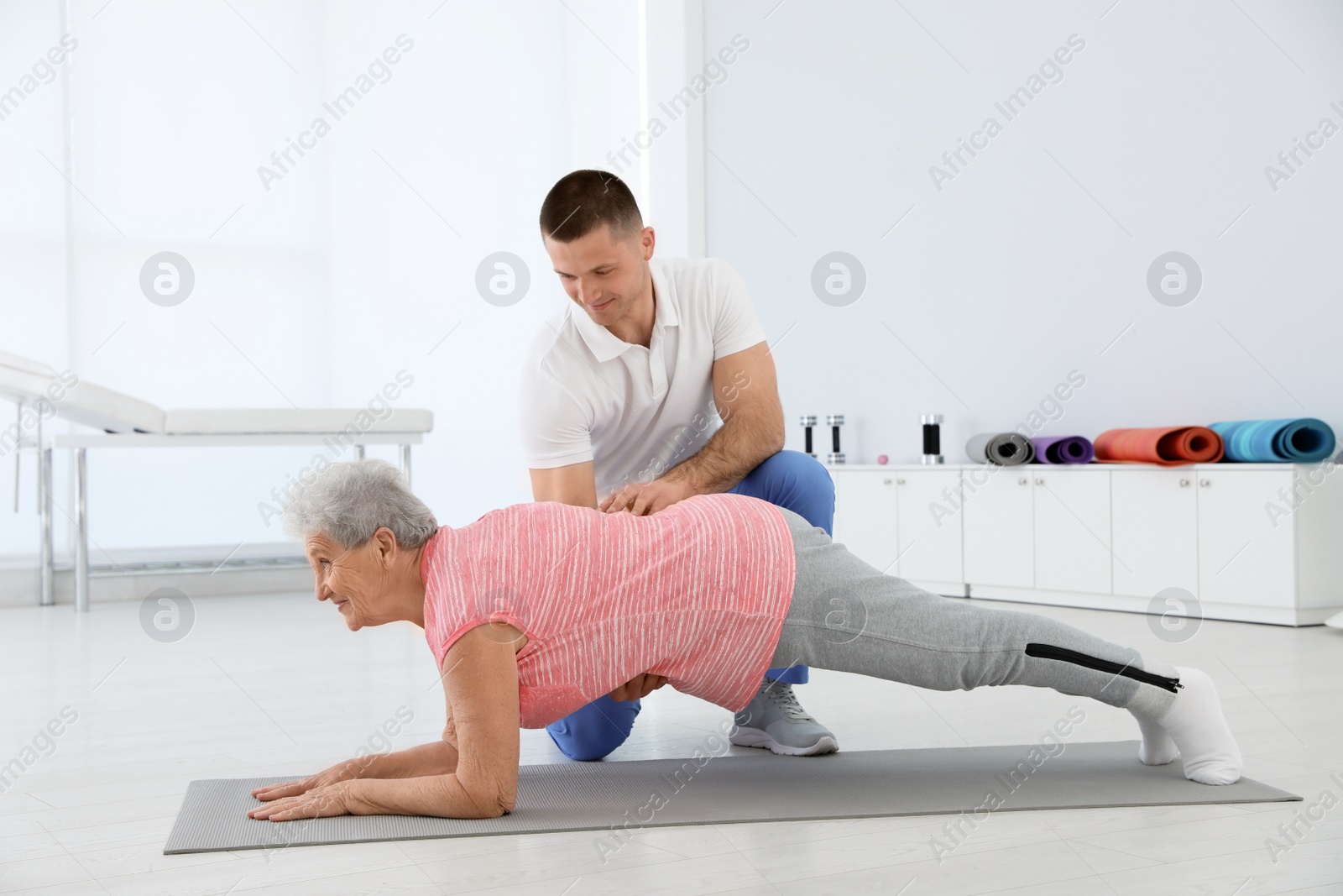 Photo of Professional physiotherapist working with elderly patient in rehabilitation center