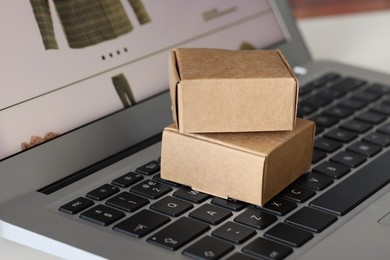 Photo of Mini boxes on laptop, closeup. Online store
