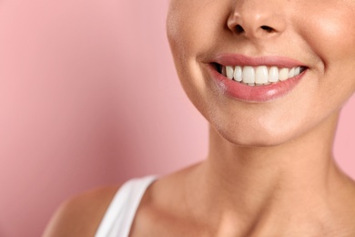 Young woman with healthy teeth on color background, closeup. Space for text