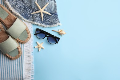 Photo of Flat lay composition with beach accessories on light blue background, space for text