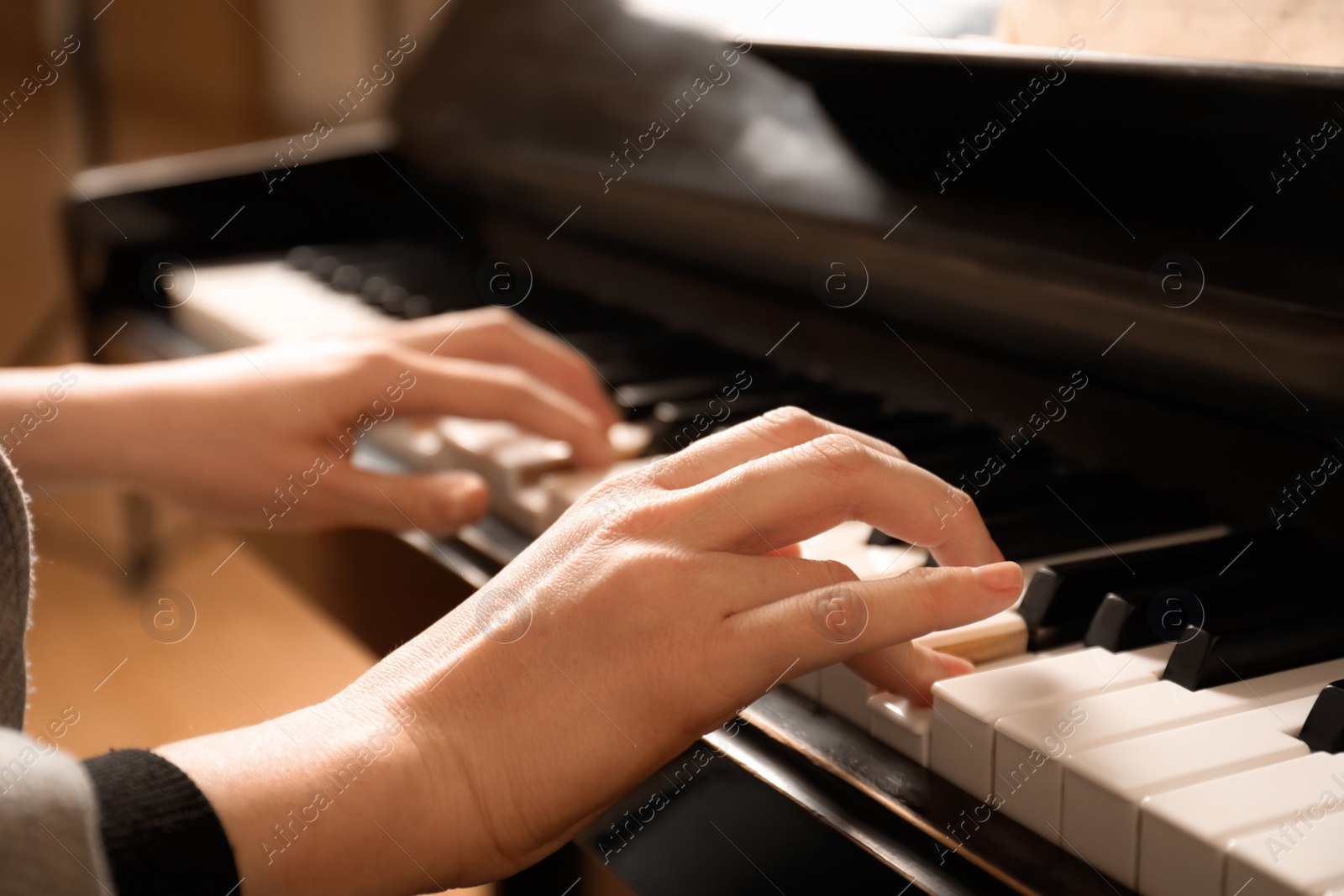 Photo of Young woman playing piano, closeup. Music lesson