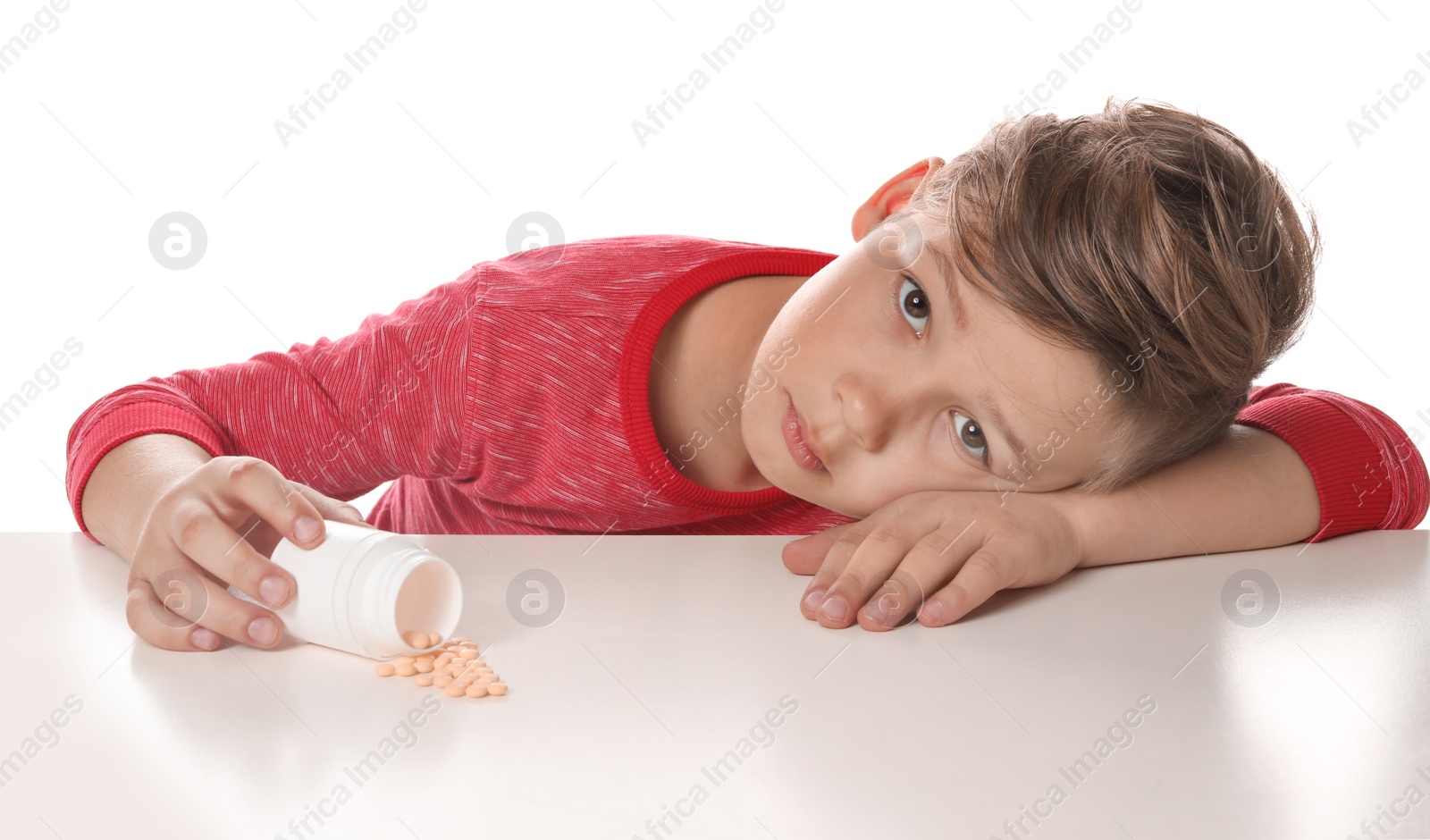 Photo of Little child with pills on white background. Danger of medicament intoxication