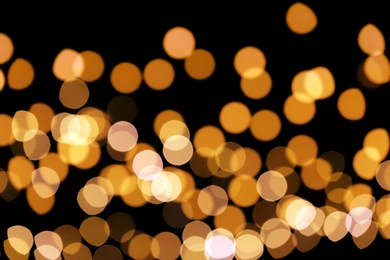 Photo of Beautiful golden lights on dark background. Bokeh effect