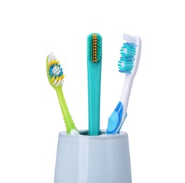 Photo of Different toothbrushes in holder isolated on white