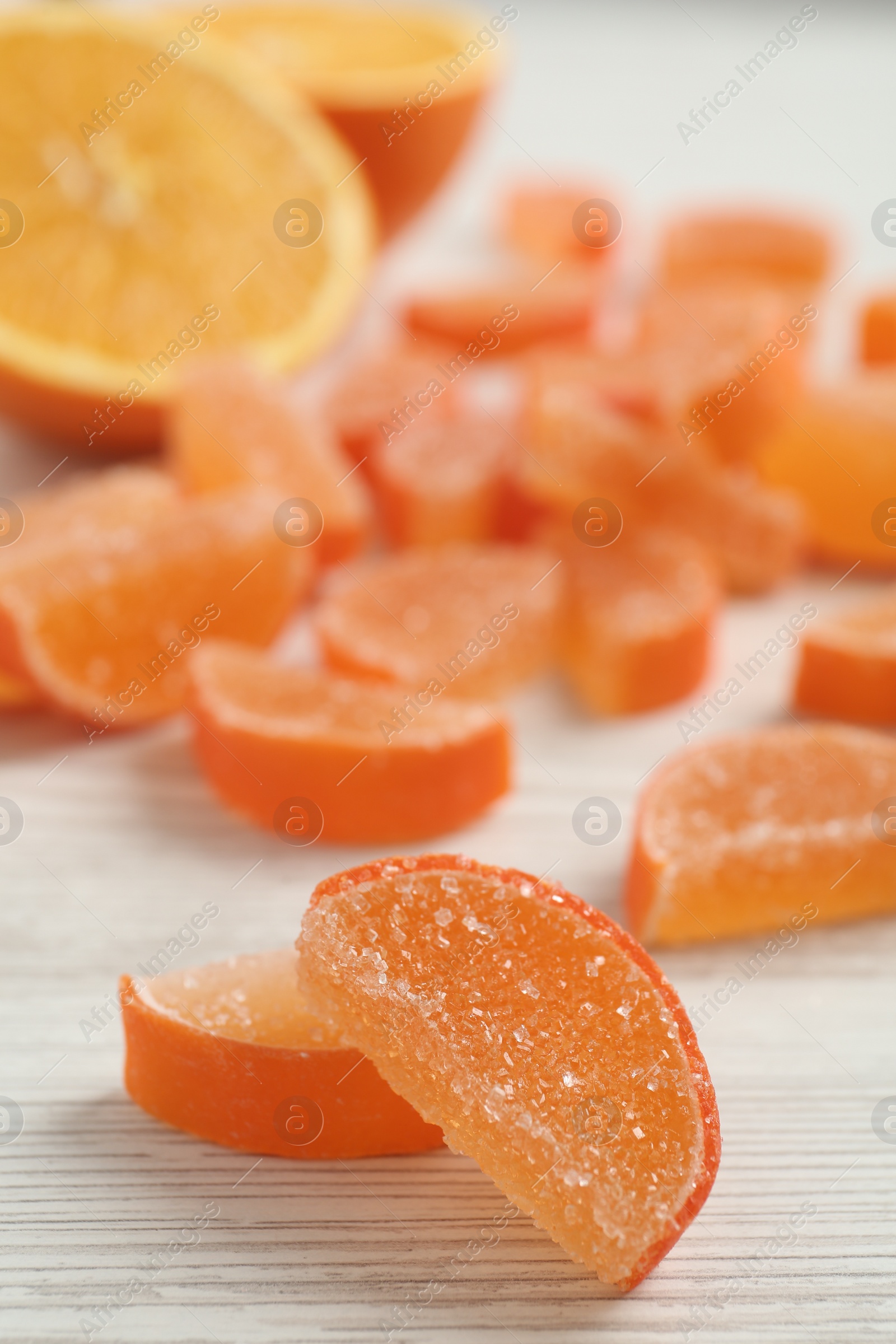 Photo of Tasty orange jelly candies on white table. Space for text