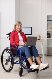 Photo of Woman in wheelchair using laptop at home