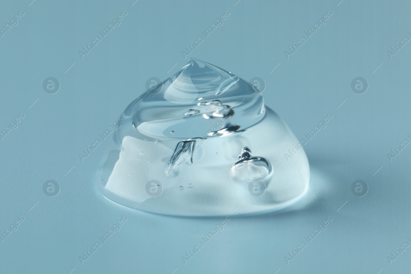 Photo of Sample of clear cosmetic gel on light blue background, closeup