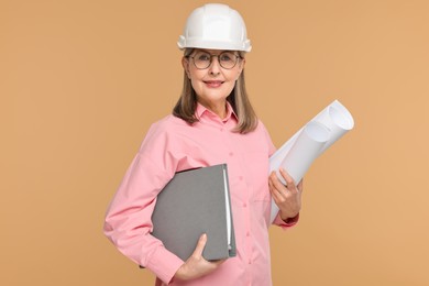 Photo of Architect in hard hat with drafts and folder on beige background