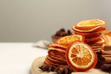 Photo of Dry orange slices., anise stars and cinnamon sticks on white table, closeup. Space for text