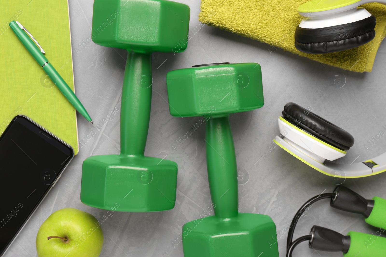 Photo of Flat lay composition with dumbbells on light grey table