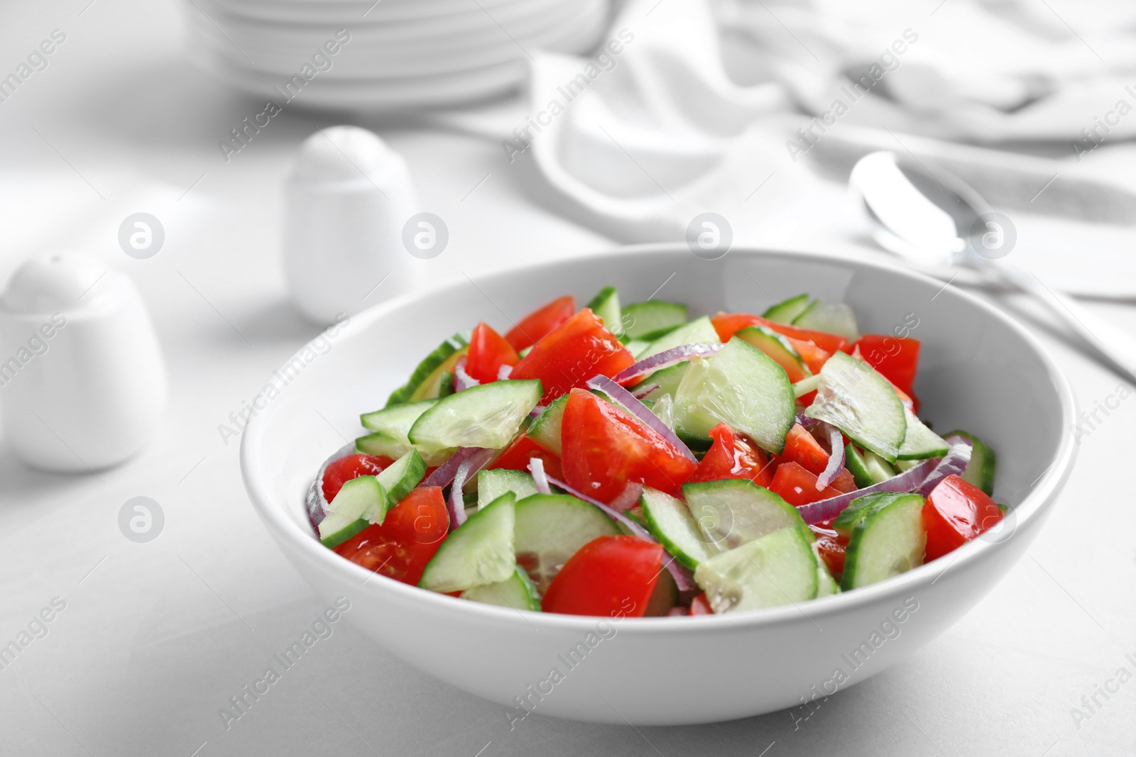 Photo of Delicious fresh cucumber tomato salad in bowl on table