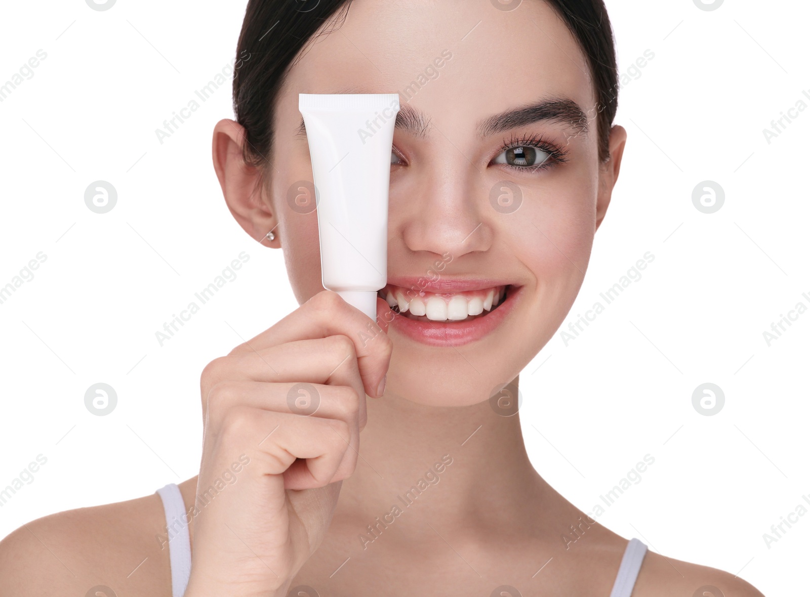 Photo of Teenage girl holding tube of foundation on white background