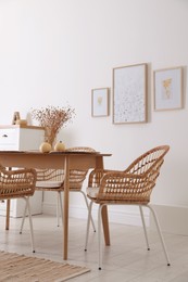 Dining room interior with wooden table and wicker chairs