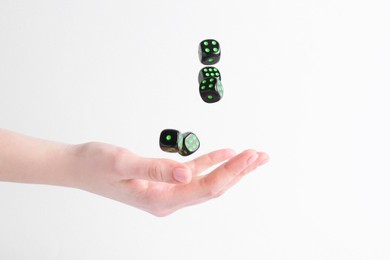 Woman throwing game dices on white background, closeup