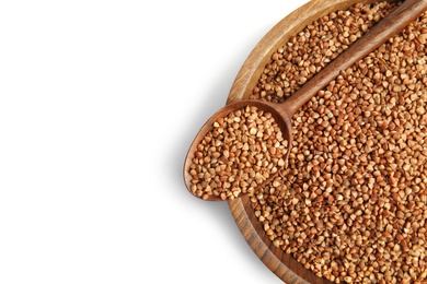 Bowl and spoon with uncooked buckwheat on white background, top view