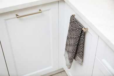 Photo of Clean towel on cabinet door in kitchen
