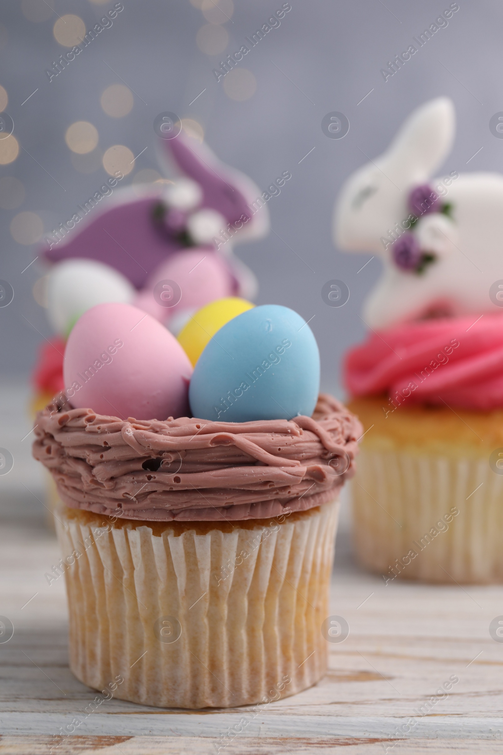 Photo of Tasty decorated Easter cupcakes on wooden table, closeup