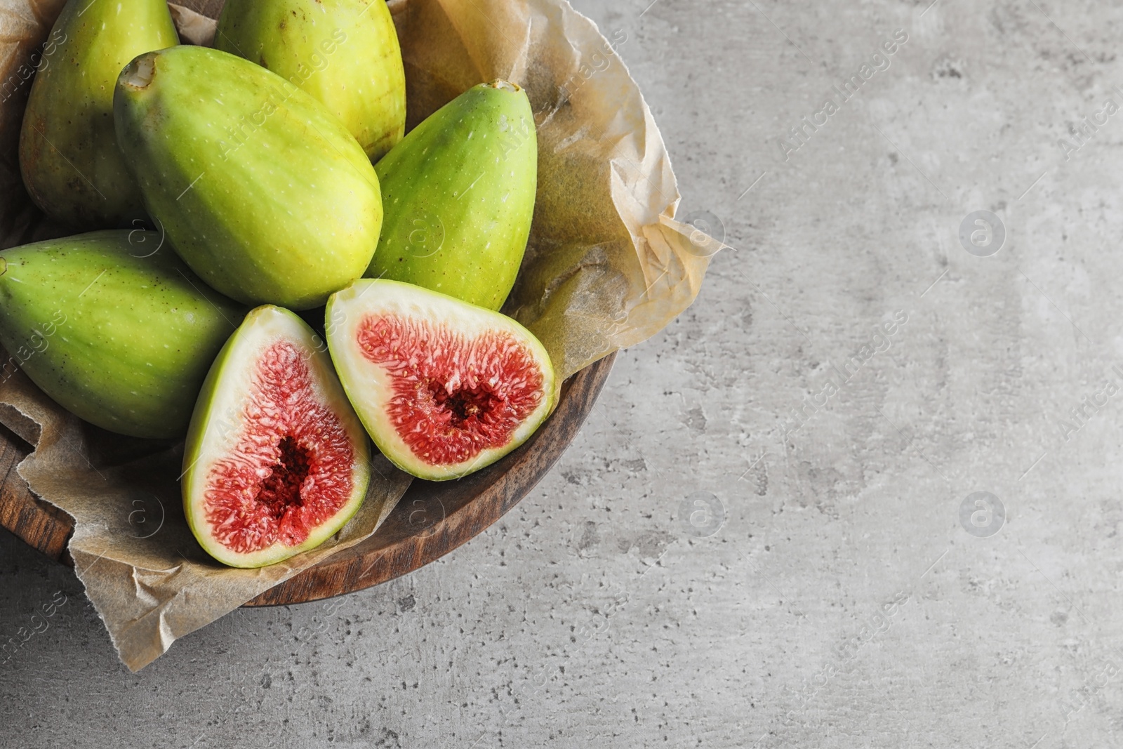 Photo of Bowl with fresh ripe figs on gray background, top view