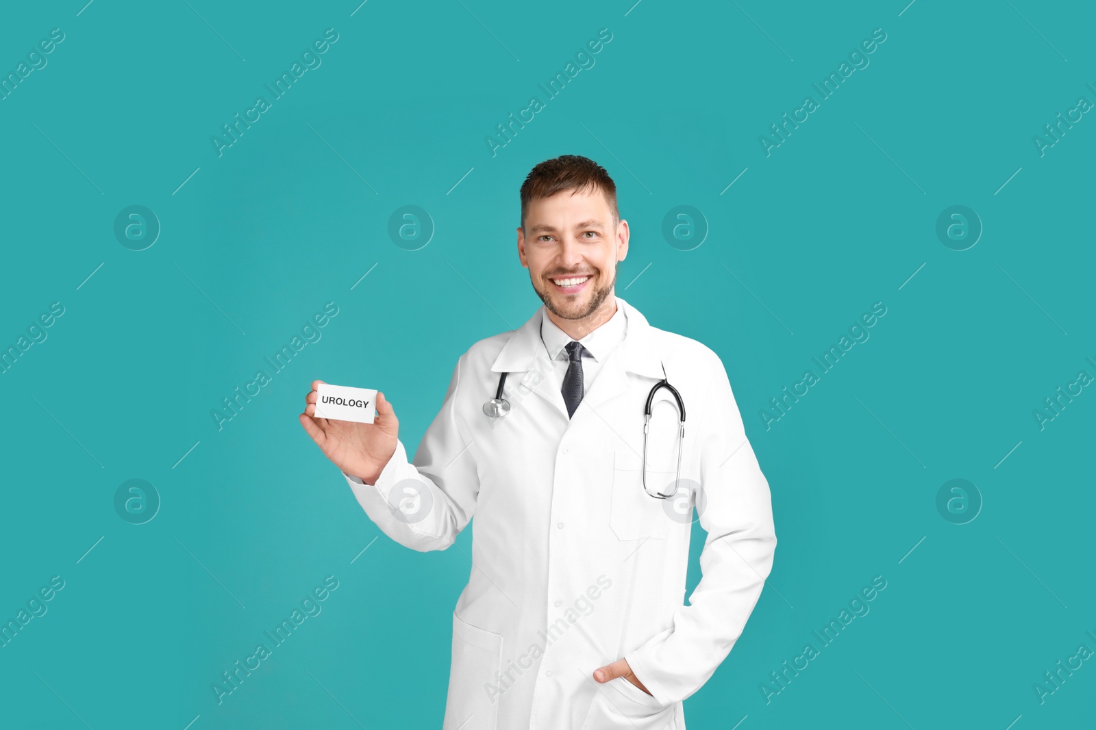 Photo of Male doctor holding card with word UROLOGY on turquoise background