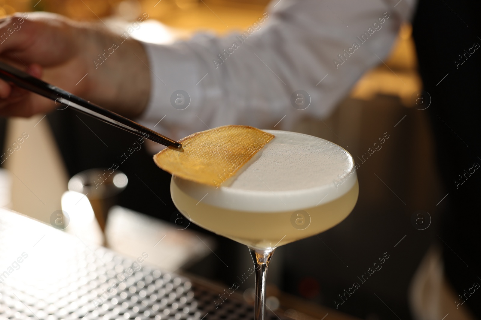 Photo of Bartender making fresh alcoholic cocktail at bar counter, closeup