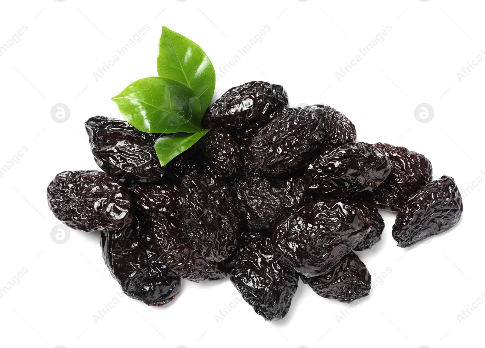 Photo of Heap of sweet dried prunes and green leaves on white background