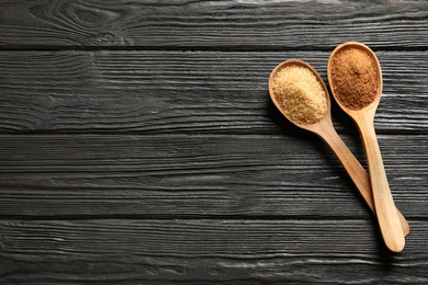 Spoons with brown sugar on wooden table