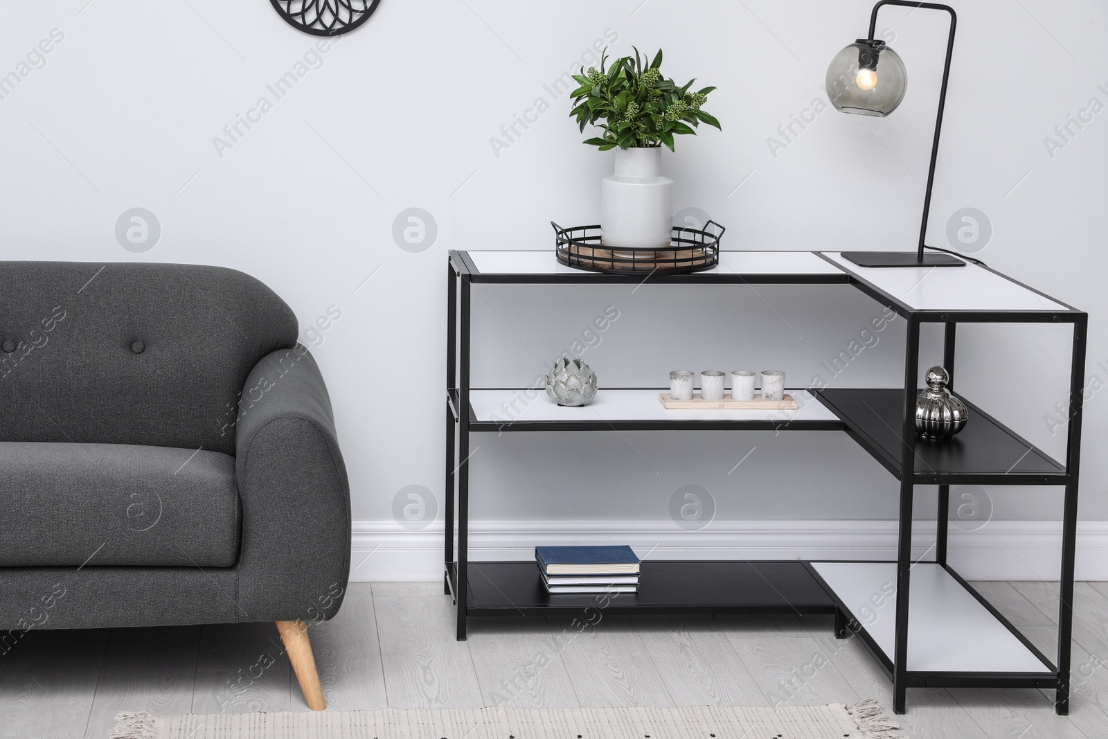 Photo of Console table with sofa near light wall in room. Interior design