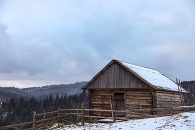 Photo of Winter landscape with old hut on snowy slope